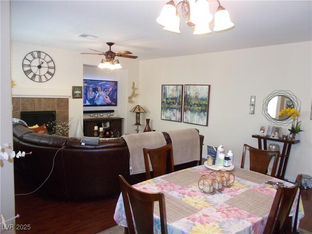 11832 Arenoso Dr, Las Vegas, NV 89138 - dining space with a chandelier, wood finished floors, ceiling fan, and a tile fireplace