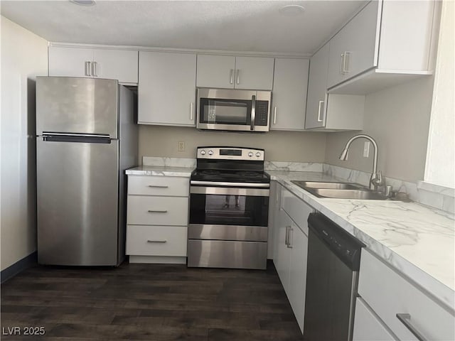 3930 University Center Dr Unit 901, Las Vegas, NV 89119 - kitchen featuring stainless steel appliances, dark wood-type flooring, white cabinetry, and light stone countertops