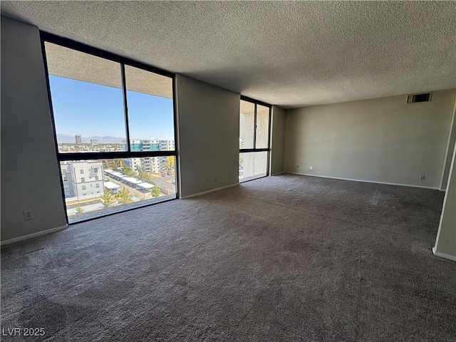 3930 University Center Dr Unit 901, Las Vegas, NV 89119 - unfurnished room with a wall of windows, carpet flooring, a textured ceiling, and a view of city