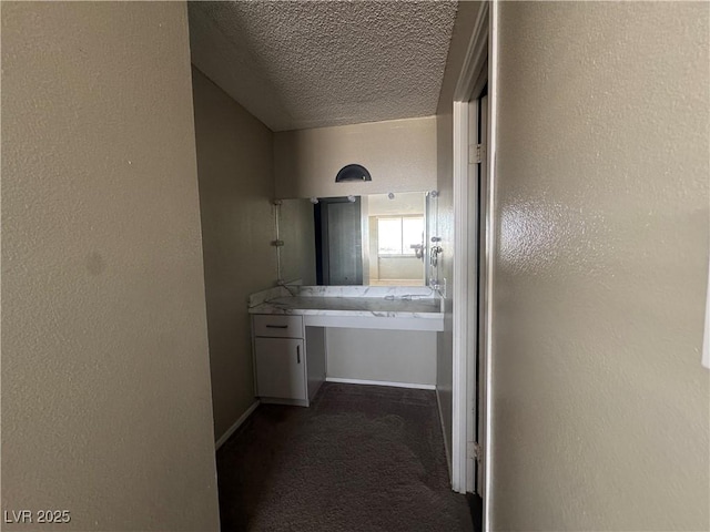 3930 University Center Dr Unit 901, Las Vegas, NV 89119 - hall with dark carpet, a textured wall, and a textured ceiling