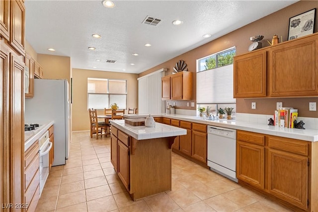 2366 Brockton Way, Henderson, NV 89074 - kitchen with white appliances, tile countertops, recessed lighting, a kitchen island, and brown cabinets