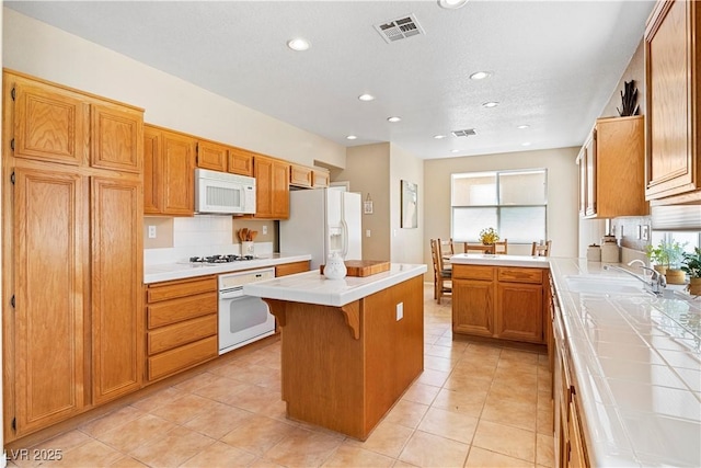 2366 Brockton Way, Henderson, NV 89074 - kitchen with white appliances, tile counters, a kitchen island, recessed lighting, and light tile patterned floors