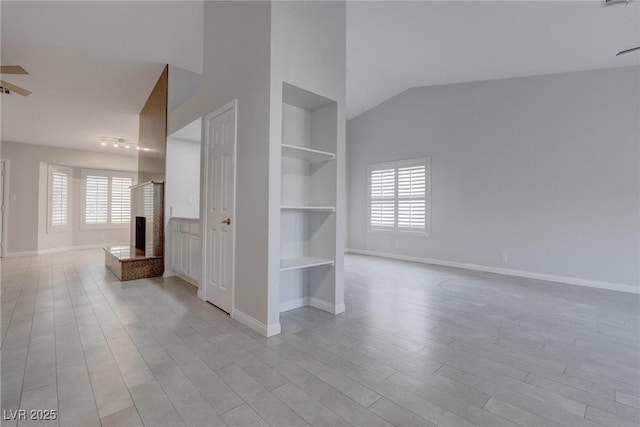 1516 Frandosa Ln, Las Vegas, NV 89117 - spare room with built in shelves, healthy amount of natural light, a multi sided fireplace, wood finished floors, and vaulted ceiling