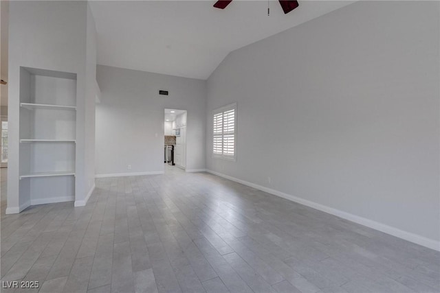1516 Frandosa Ln, Las Vegas, NV 89117 - unfurnished living room featuring a ceiling fan, built in shelves, wood finished floors, and vaulted ceiling