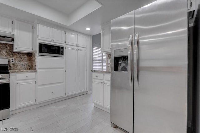 1516 Frandosa Ln, Las Vegas, NV 89117 - kitchen featuring appliances with stainless steel finishes, light stone countertops, white cabinetry, backsplash, and range hood