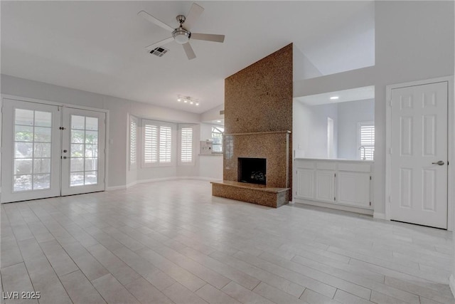 1516 Frandosa Ln, Las Vegas, NV 89117 - unfurnished living room featuring a ceiling fan, high vaulted ceiling, a large fireplace, light wood-style floors, and french doors
