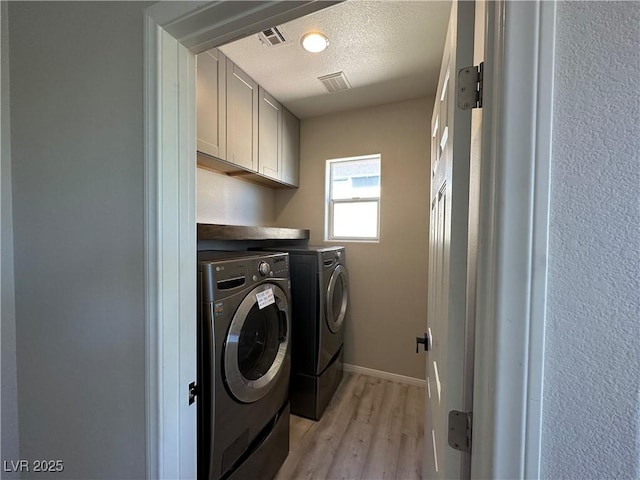 7537 Brisa Del Mar Ave, Las Vegas, NV 89179 - laundry area featuring washing machine and dryer, cabinet space, light wood-style floors, and a textured ceiling