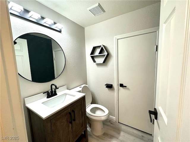 7537 Brisa Del Mar Ave, Las Vegas, NV 89179 - half bath with wood finished floors, vanity, a textured wall, and a textured ceiling