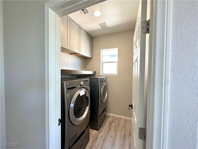 7537 Brisa Del Mar Ave, Las Vegas, NV 89179 - laundry room featuring washer and clothes dryer, cabinet space, light wood finished floors, and a textured ceiling