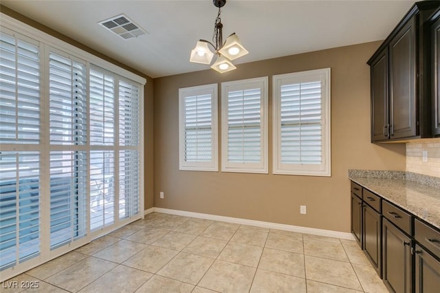 11063 Mount George St, Las Vegas, NV 89179 - unfurnished dining area featuring light tile patterned floors, healthy amount of natural light, and a chandelier