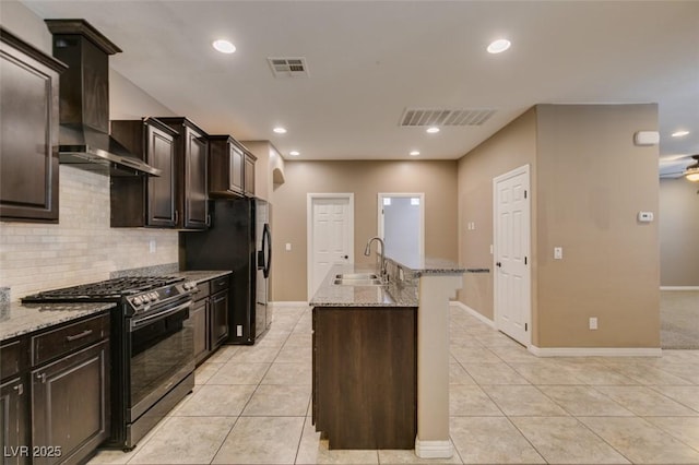 11063 Mount George St, Las Vegas, NV 89179 - kitchen with black appliances, wall chimney range hood, light stone countertops, decorative backsplash, and light tile patterned floors