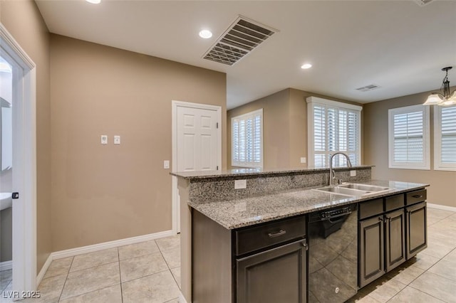 11063 Mount George St, Las Vegas, NV 89179 - kitchen featuring black dishwasher, light tile patterned floors, light stone counters, recessed lighting, and hanging light fixtures