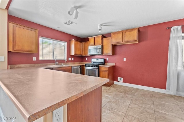 9175 Titan Hill Ct, Las Vegas, NV 89148 - kitchen featuring stainless steel appliances, a peninsula, brown cabinets, and light countertops