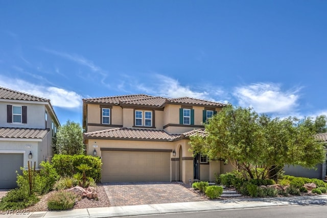 9785 W Meranto Ave, Las Vegas, NV 89178 - mediterranean / spanish home with an attached garage, decorative driveway, stucco siding, and a tiled roof
