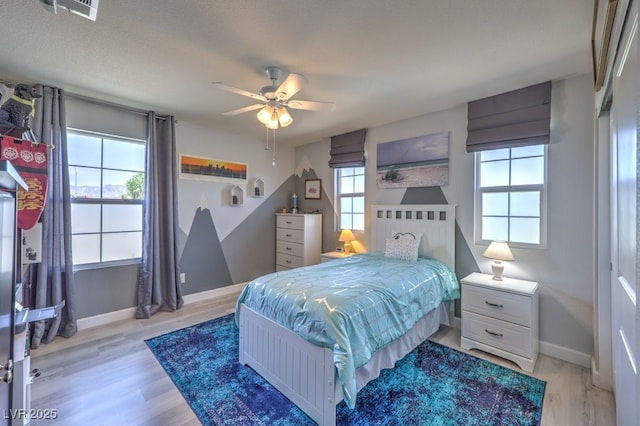 9785 W Meranto Ave, Las Vegas, NV 89178 - bedroom featuring multiple windows, light wood-style flooring, and a ceiling fan