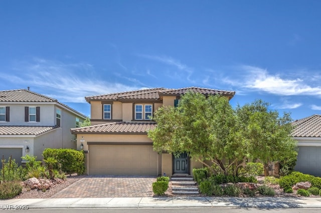 9785 W Meranto Ave, Las Vegas, NV 89178 - mediterranean / spanish house with a tile roof, decorative driveway, stucco siding, and an attached garage