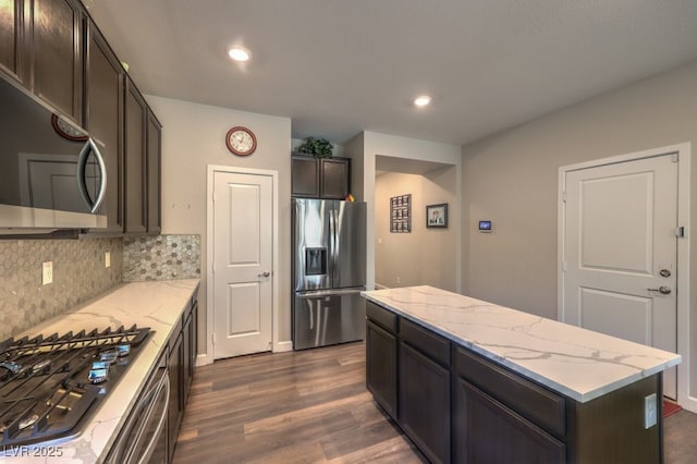 9785 W Meranto Ave, Las Vegas, NV 89178 - kitchen featuring stainless steel appliances, dark wood-style flooring, a kitchen island, light stone counters, and recessed lighting