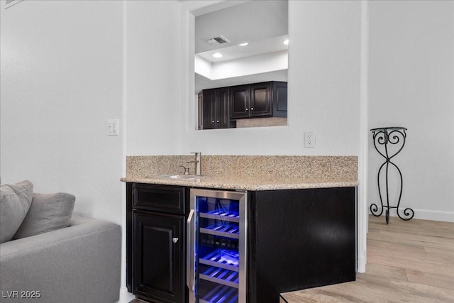 7627 Boca Raton Dr, Las Vegas, NV 89113 - indoor wet bar with wine cooler, light wood-type flooring, recessed lighting, and a tray ceiling