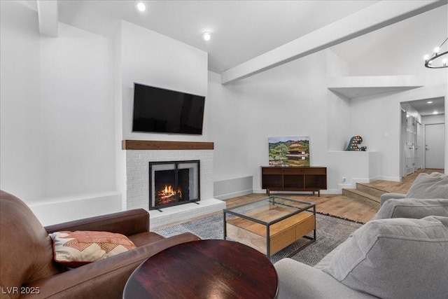 7627 Boca Raton Dr, Las Vegas, NV 89113 - living room featuring vaulted ceiling, a fireplace, wood finished floors, and a chandelier