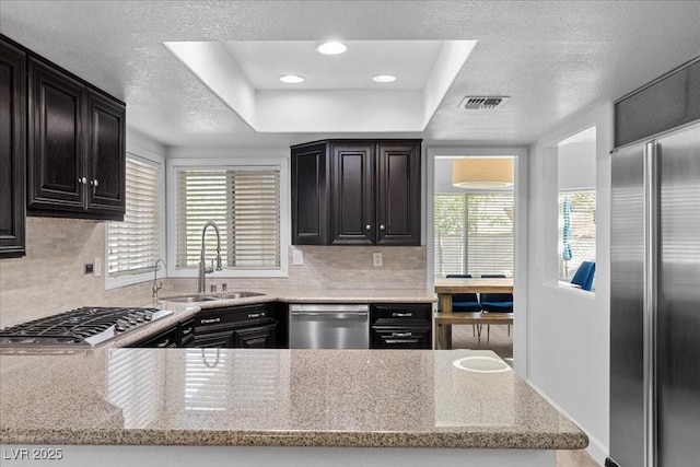 7627 Boca Raton Dr, Las Vegas, NV 89113 - kitchen featuring stainless steel appliances, tasteful backsplash, light stone counters, dark cabinets, and a textured ceiling