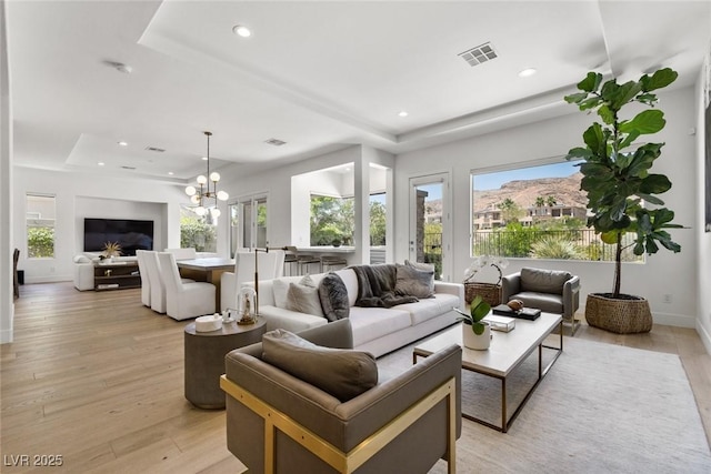 2797 Turtle Head Peak Dr, Las Vegas, NV 89135 - living room with a tray ceiling, light wood-style flooring, recessed lighting, and a chandelier