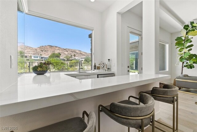 2797 Turtle Head Peak Dr, Las Vegas, NV 89135 - kitchen with a mountain view, a breakfast bar, healthy amount of natural light, and wood finished floors