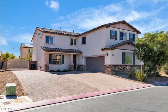 5425 Pride Mountain St, North Las Vegas, NV 89031 - view of front of house featuring stone siding, a garage, decorative driveway, a gate, and stucco siding