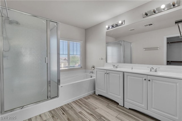 5425 Pride Mountain St, North Las Vegas, NV 89031 - bathroom with a bath, a stall shower, double vanity, and wood finished floors