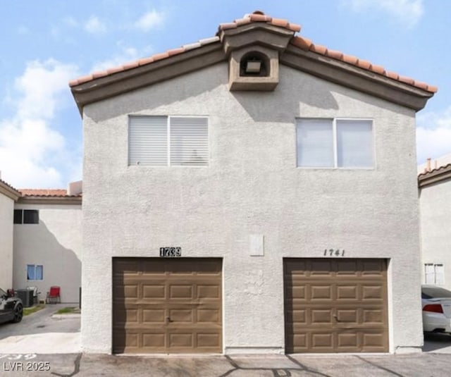 1739 N Lamont St, Las Vegas, NV 89115 - view of front of house with a garage, a tiled roof, and stucco siding