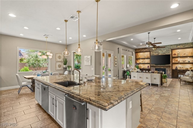 9747 Cathedral Pines Ave, Las Vegas, NV 89149 - kitchen with recessed lighting, a ceiling fan, light stone countertops, a center island with sink, and decorative light fixtures