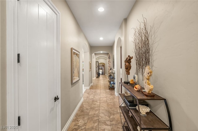 9747 Cathedral Pines Ave, Las Vegas, NV 89149 - hall with arched walkways, recessed lighting, and light stone finish flooring