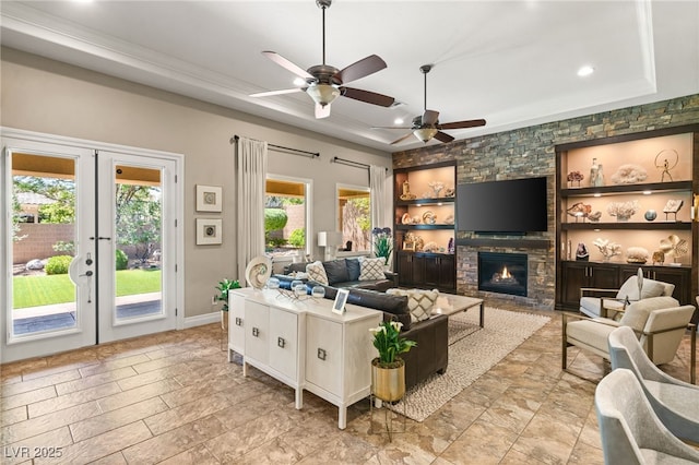 9747 Cathedral Pines Ave, Las Vegas, NV 89149 - living room with a tray ceiling, french doors, a ceiling fan, a fireplace, and recessed lighting