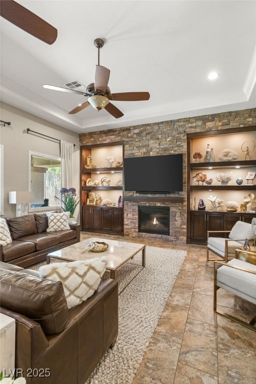 9747 Cathedral Pines Ave, Las Vegas, NV 89149 - living area with a ceiling fan, built in shelves, a fireplace, a tray ceiling, and ornamental molding