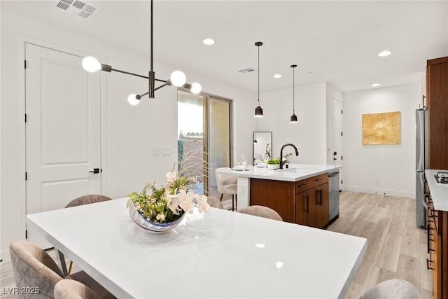 11756 Emerald Lake Ave, Las Vegas, NV 89138 - kitchen featuring appliances with stainless steel finishes, a center island with sink, light wood-type flooring, a breakfast bar, and recessed lighting