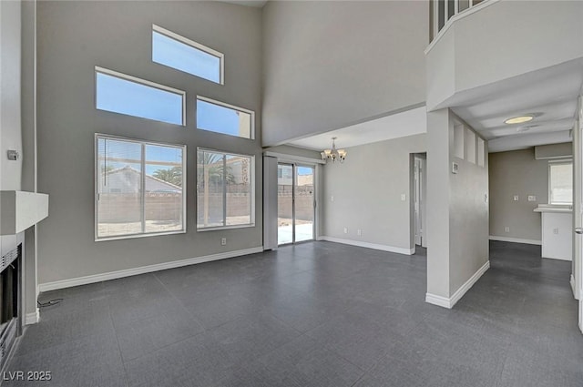 901 Carnival Ave, Las Vegas, NV 89123 - unfurnished living room with a chandelier, a fireplace, and a towering ceiling