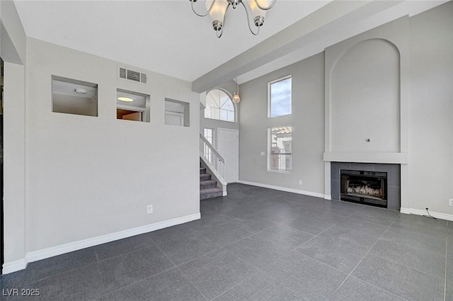 901 Carnival Ave, Las Vegas, NV 89123 - unfurnished living room featuring a towering ceiling, a tile fireplace, stairway, and a chandelier