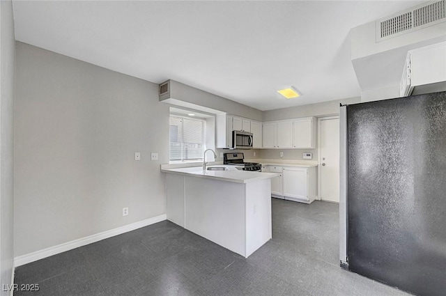 901 Carnival Ave, Las Vegas, NV 89123 - kitchen with appliances with stainless steel finishes, a peninsula, white cabinetry, light countertops, and dark flooring