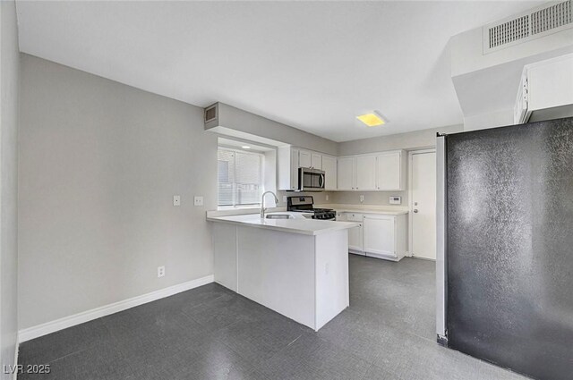 901 Carnival Ave, Las Vegas, NV 89123 - kitchen featuring stainless steel appliances, a peninsula, white cabinets, light countertops, and dark floors