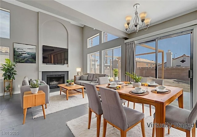 901 Carnival Ave, Las Vegas, NV 89123 - dining area featuring a chandelier, a fireplace, a high ceiling, and concrete floors