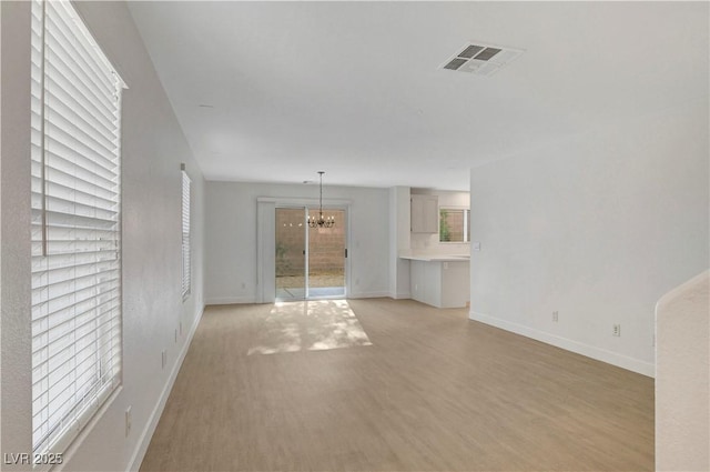 2431 Lilac Cove St, Las Vegas, NV 89135 - unfurnished living room with a chandelier and light wood-style floors