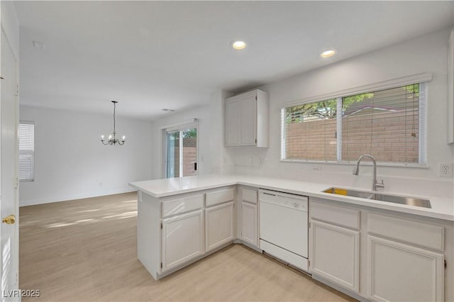 2431 Lilac Cove St, Las Vegas, NV 89135 - kitchen featuring white dishwasher, a peninsula, a chandelier, light countertops, and light wood-type flooring