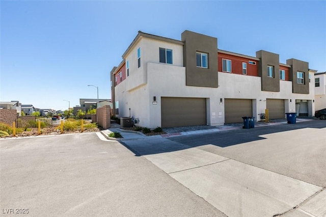 9844 Kings Glen St, Las Vegas, NV 89141 - view of front of home with a garage, a residential view, stucco siding, and driveway