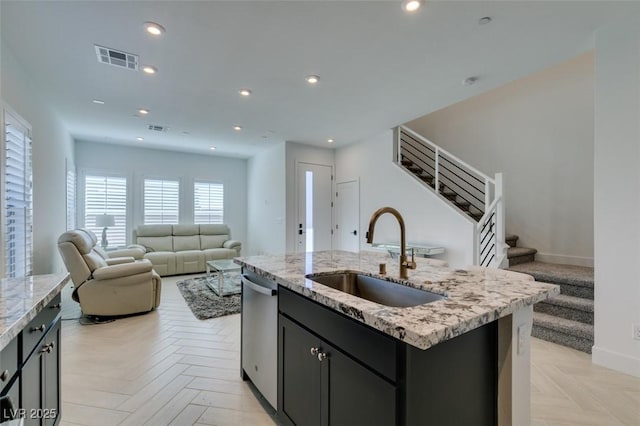 9844 Kings Glen St, Las Vegas, NV 89141 - kitchen featuring stainless steel dishwasher, an island with sink, open floor plan, light stone counters, and recessed lighting