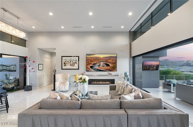 671 Scenic Rim Dr, Henderson, NV 89012 - living room featuring a towering ceiling, recessed lighting, and a lit fireplace