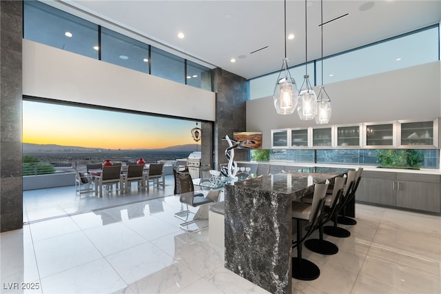 671 Scenic Rim Dr, Henderson, NV 89012 - dining room featuring a high ceiling, light marble finish flooring, floor to ceiling windows, and recessed lighting