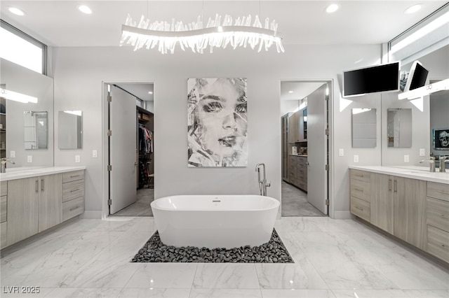 671 Scenic Rim Dr, Henderson, NV 89012 - bathroom with two vanities, a freestanding tub, marble finish flooring, recessed lighting, and a walk in closet