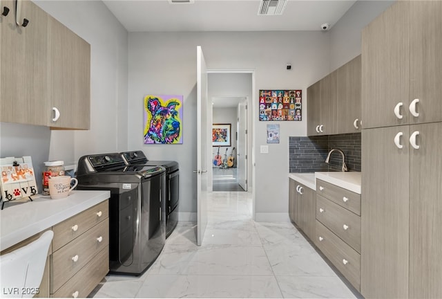 671 Scenic Rim Dr, Henderson, NV 89012 - laundry area featuring washer and clothes dryer, cabinet space, and light marble finish flooring
