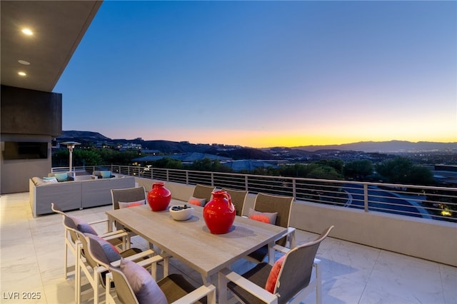 671 Scenic Rim Dr, Henderson, NV 89012 - patio terrace at dusk with a mountain view, a balcony, and outdoor dining space
