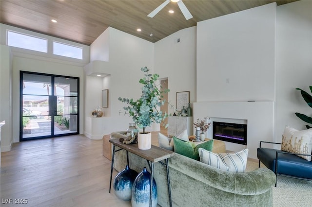9425 Villa Ridge Dr, Las Vegas, NV 89134 - living area featuring high vaulted ceiling, wood ceiling, light wood finished floors, a glass covered fireplace, and a ceiling fan