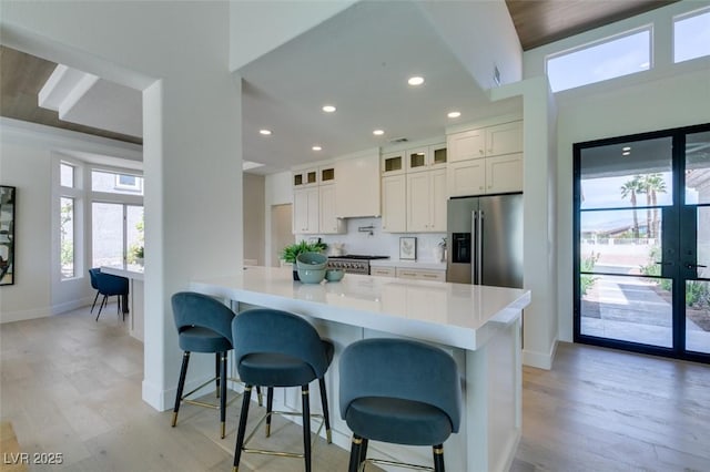 9425 Villa Ridge Dr, Las Vegas, NV 89134 - kitchen featuring stainless steel fridge, a breakfast bar area, recessed lighting, light wood-style flooring, and light countertops